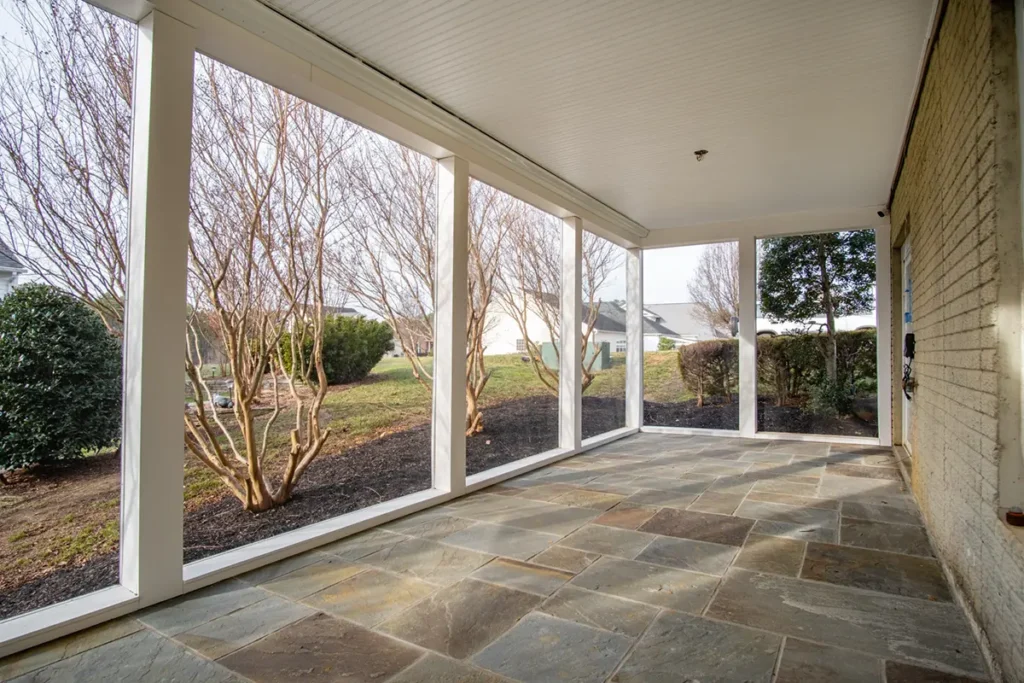 Screened porch with a flagstone floor and white framed screen panels