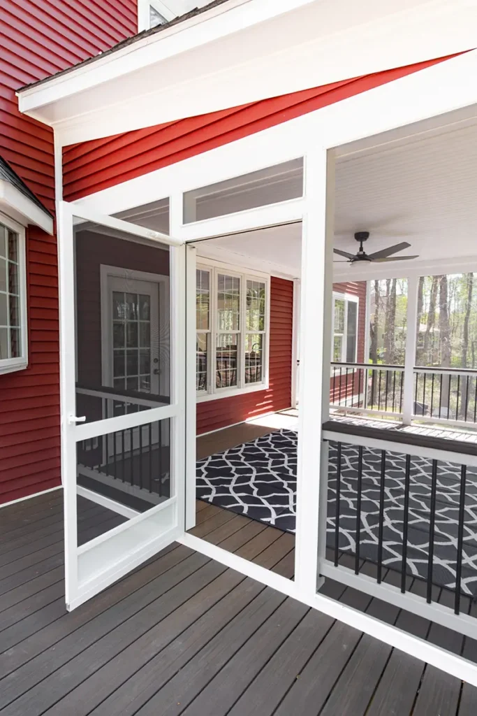ScreenEze style screened porch with white framed screen panels and a screen door over composite decking