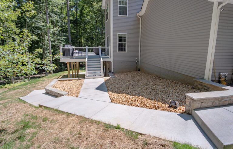 Concrete sidewalk leading to the deck, with a concrete patio below and an integrated rain system — hardscape by Fredericksburg Deck Builders, Fredericksburg VA
