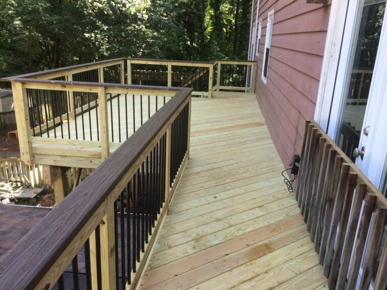 Wood deck walkway with dark rail cap and black balusters — deck railing by Fredericksburg Deck Builders, Fredericksburg VA