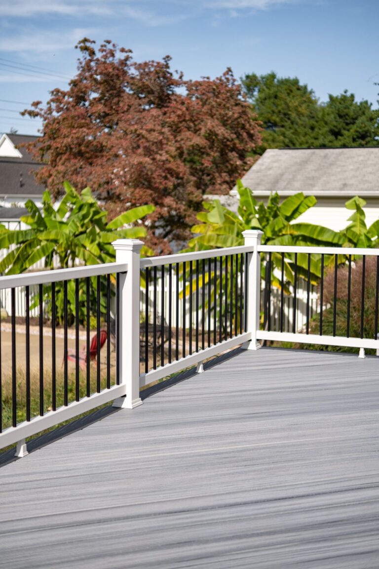 White railing with black balusters on a gray deck — deck railing by Fredericksburg Deck Builders, Fredericksburg VA